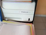 a stack of papers and a printer sitting on a desk
