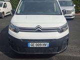 la camionnette blanche est garée dans le parking à côté d'autres voitures