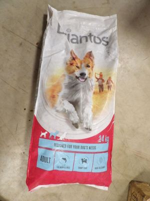 un sac de croquettes posé par terre à côté d'une bouteille d'eau