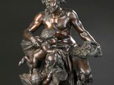 une image représentant une statue en bronze d'un homme assis sur un rocher