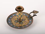 an antique brass candle holder with a blue and yellow floral design