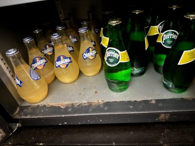 many bottles of beer on a shelf in a refrigerator