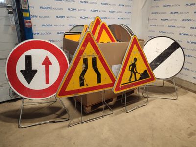 three road signs that are on display in front of a wall