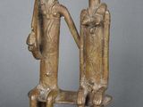 deux figurines en bronze représentant deux personnes assises sur un banc