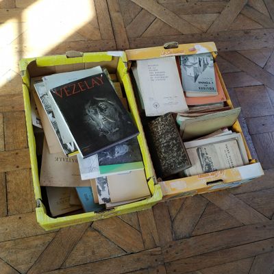 a yellow box filled with books on a wooden floor