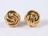 a close up of a pair of gold earrings on a white surface