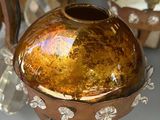 a brown vase sitting on top of a table next to other vases