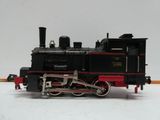 un train noir et rouge posé sur une surface blanche