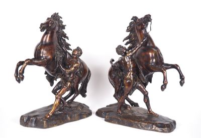deux statues de chevaux en bronze posées sur un rocher, sur fond blanc