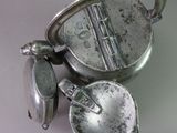 a silver teapot with a spoon and a spoon rest on a table