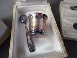 a silver cup and spoon in a box on a table
