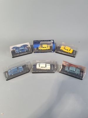 six toy cars are in plastic boxes on a table