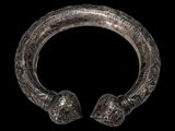 a close up of a silver bracelet on a black background