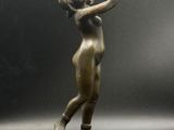 une image représentant une statue en bronze d'une femme tenant une raquette de tennis