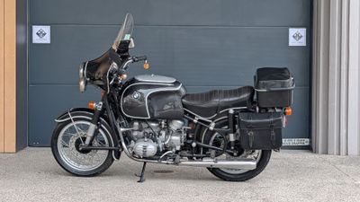 a black motorcycle parked in front of a garage door