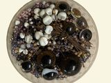 a glass bowl filled with lots of black and white beads