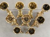 five brass candlesticks sitting on a table