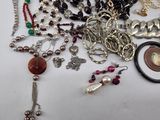 many different types of necklaces and bracelets laid out on a table