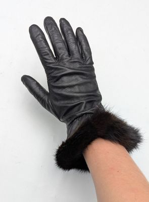des gants en cuir noir avec des poignets en fourrure, portés par une femme