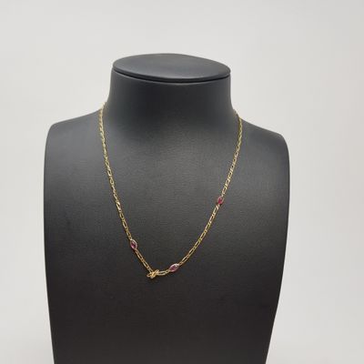 a gold chain necklace with pink stones on a mannequin