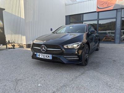 une Mercedes CLA noire garée devant un immeuble