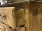 a wooden dresser with drawers and a mirror in the background