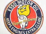 un panneau portant l'inscription « Esso Motor Oil » sur le côté d'un mur blanc