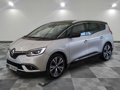 une voiture blanche est garée dans une pièce au sol à carreaux