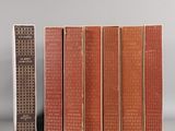 Plusieurs livres sont alignés sur une étagère à côté d'une télécommande