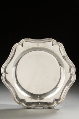 a silver plate with a scalloped edge on a white surface