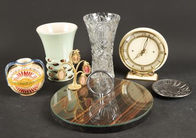 a glass table with a clock, vase, and other items on it