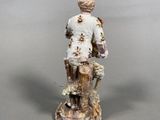 figurine of a man with a dog and a basket of flowers