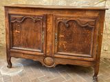 a wooden cabinet that is sitting on a brick floor
