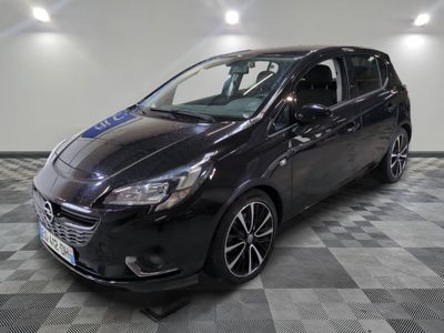 une voiture noire est garée dans une pièce au sol en damier