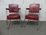 pair of red leather office chairs with chrome frame legs