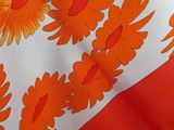 an orange and white table cloth with orange flowers on it