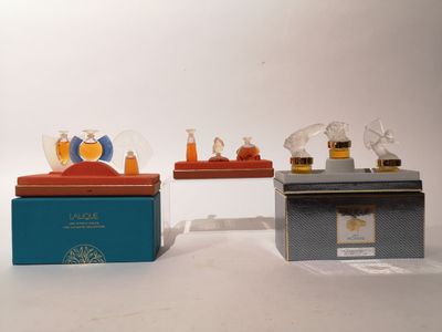 trois flacons de parfum miniatures sont posés sur une boîte