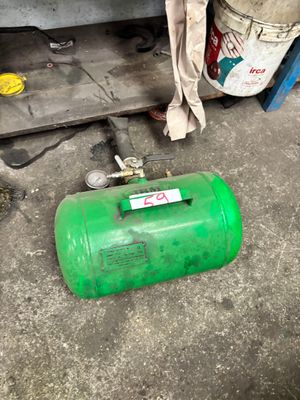 a green gas can sitting on the floor next to a shelf