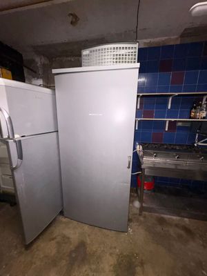 two refrigerators that are in a dirty room