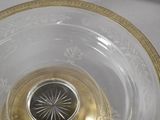 a glass bowl with a gold rim on a white table