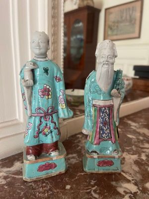 pair of chinese figurines of a man and a woman on a table