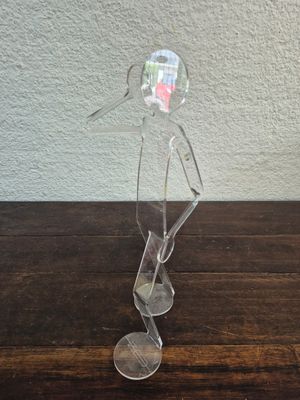 une figurine en verre transparent représentant un homme coiffé d'un chapeau