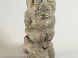 a stone statue of a man sitting on a rock