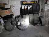 un tas de pneus dans un garage, à côté d'un autre tas de pneus