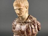 a white marble bust of a man on a pedestal