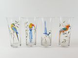 four glasses with birds painted on them sitting on a white surface
