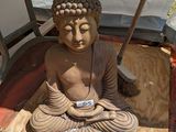 une statue représentant une personne assise en position du lotus