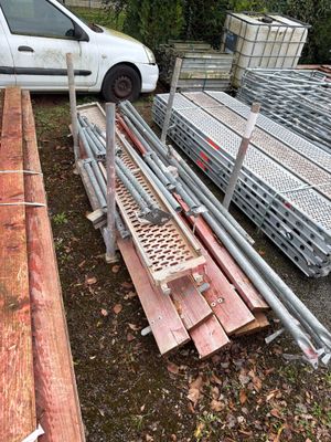 une voiture blanche garée à côté d'un tas de bois
