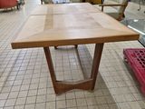 a wooden table with a glass top in a store