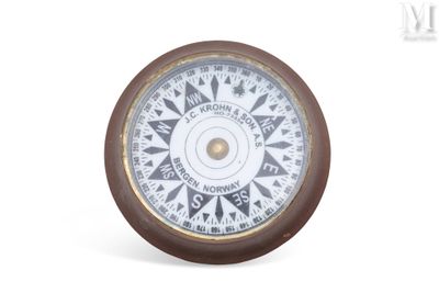 une horloge sur laquelle figure une boussole, sur fond blanc